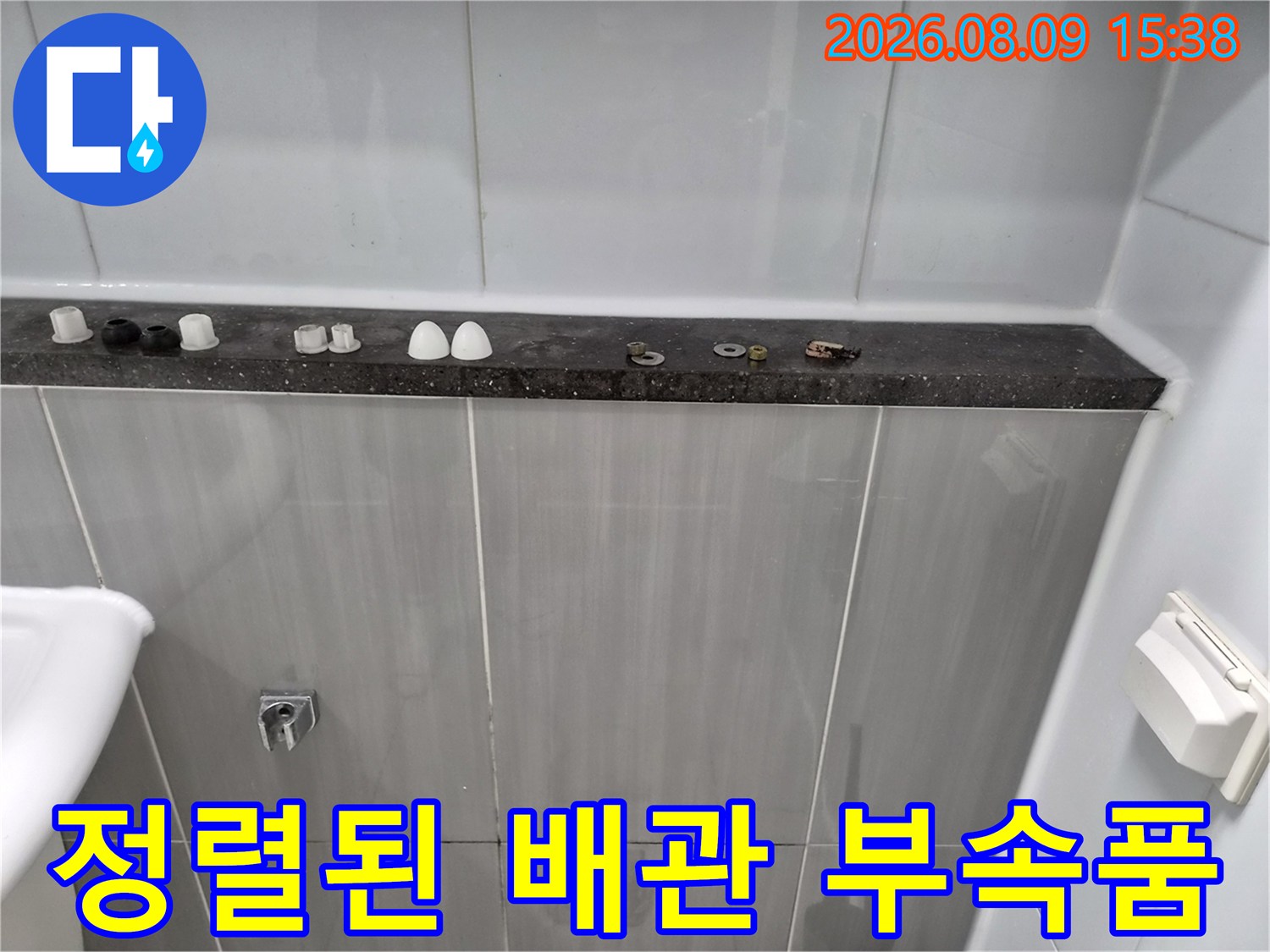 욕실 선반 위에-가지런히 놓여 있는 배관 교체용 자재들