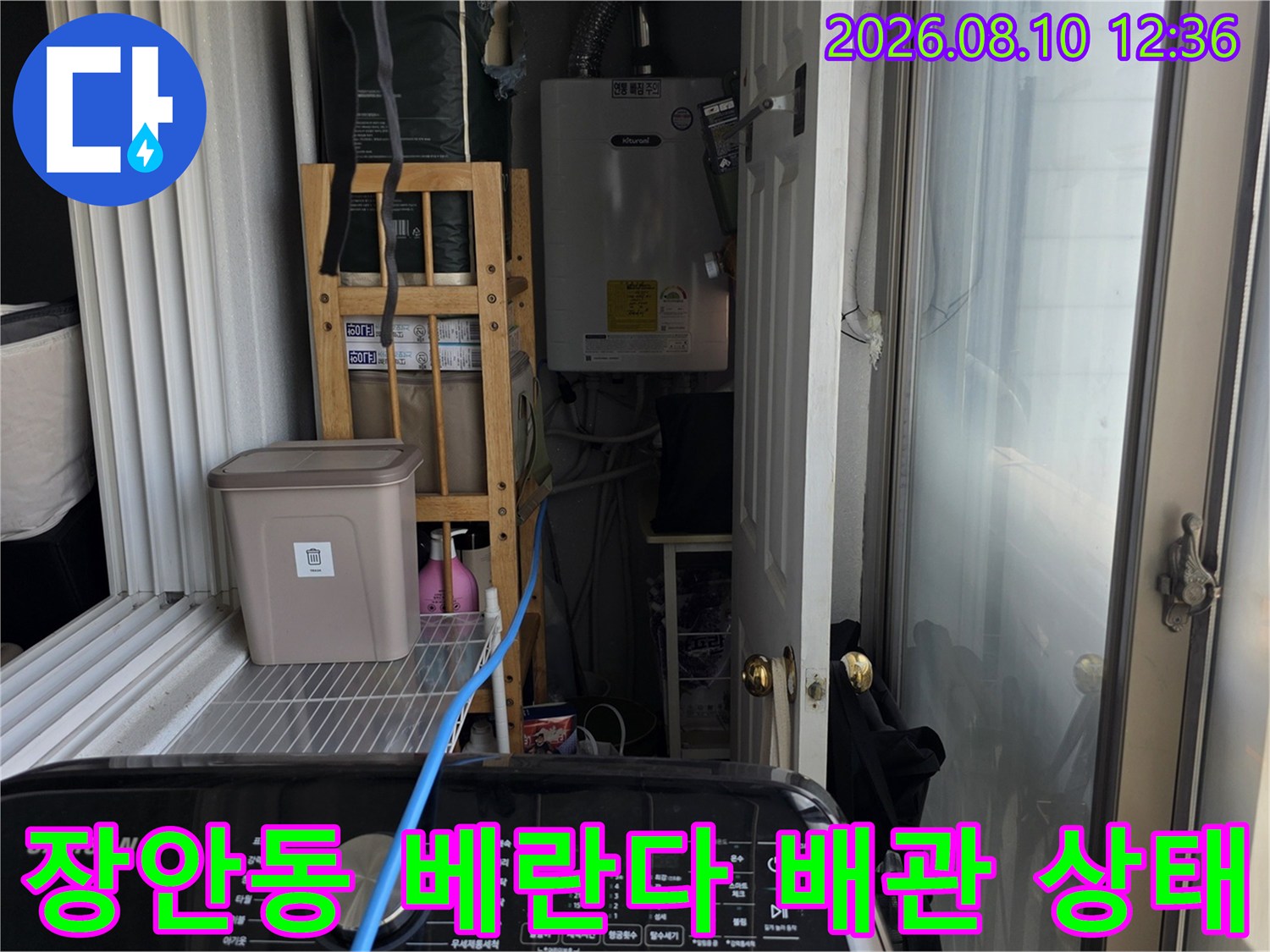 베란다 벽면에 설치된 수도 계량기와 외부 연결 배관의 상세 모습입니다.