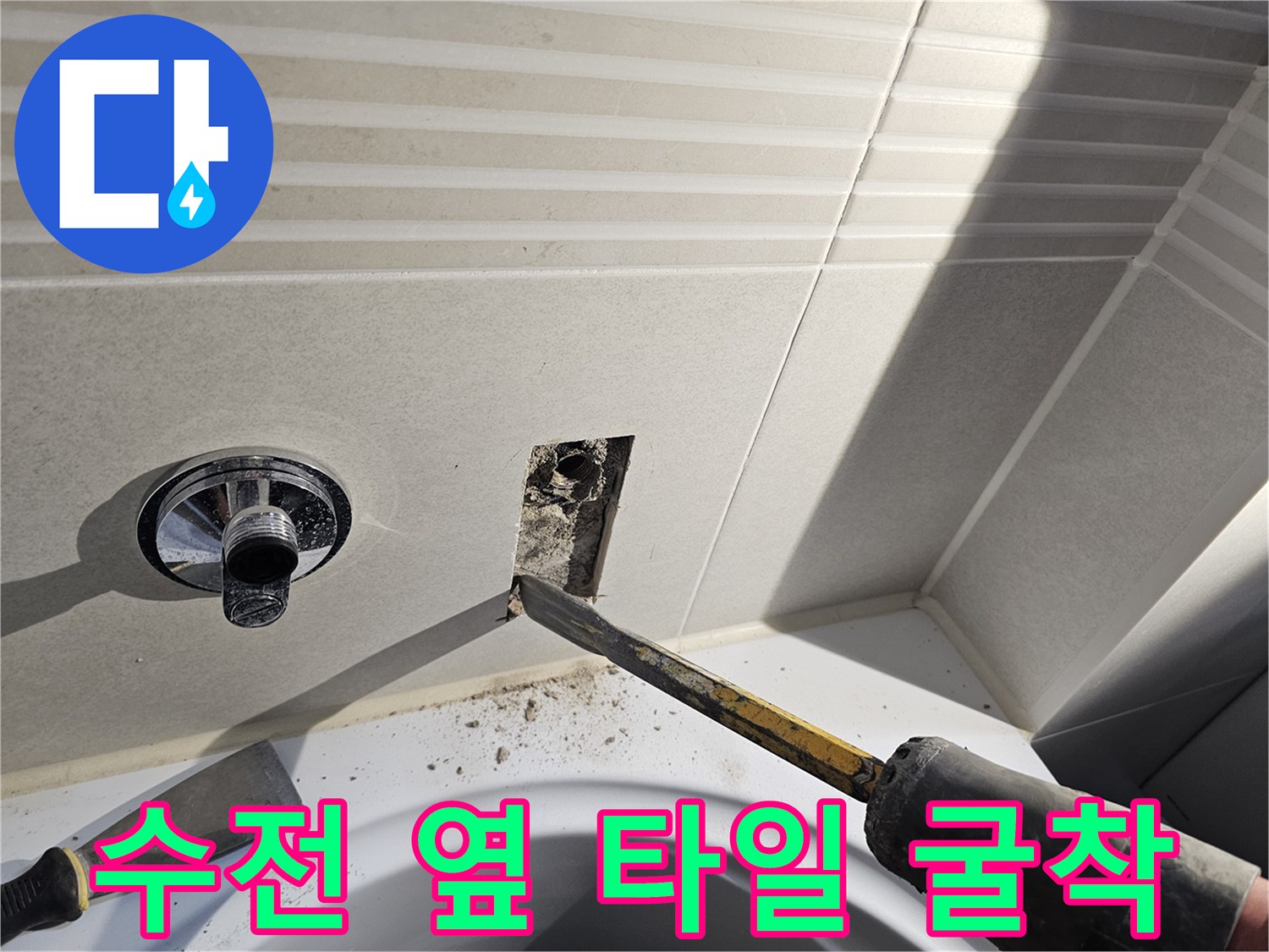 수도꼭지 주변 벽면 타일을 제거하여 내부 배관을 노출시키는 과정입니다.