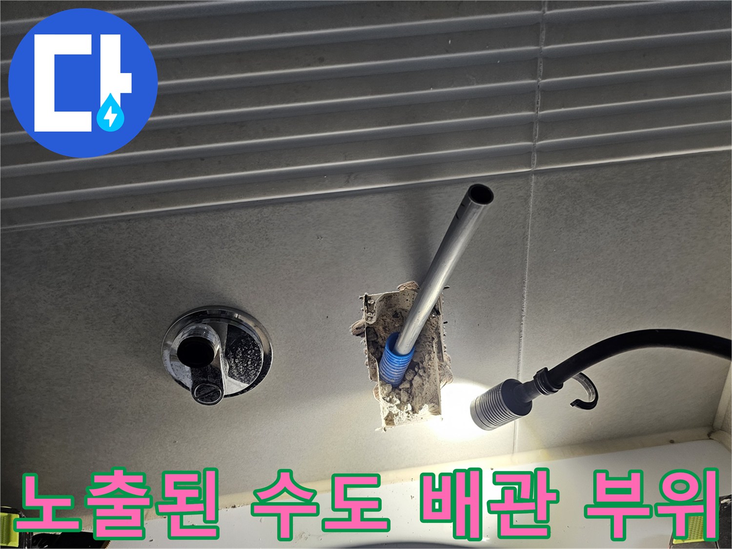 화장실 벽면을 뚫고 드러난 노출된 배관 연결부