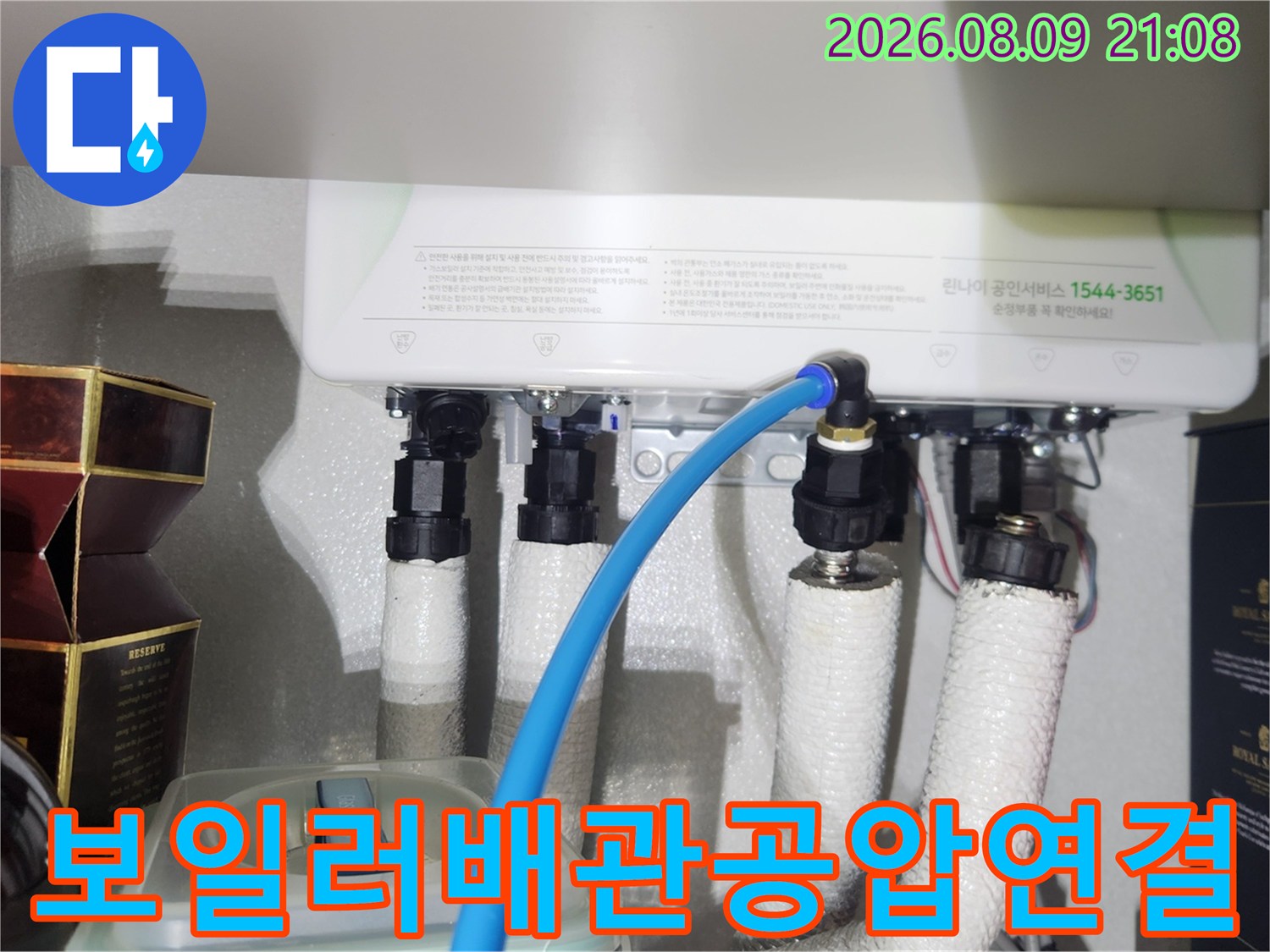 보일러 하단 배관에 파란색 공압 테스트 호스가 연결된 모습
