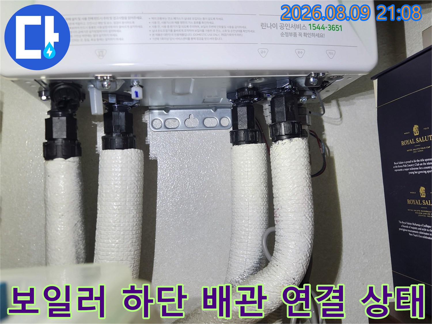 흰색 보온재로 감싸진 보일러 하단 배관들이 나란히 연결되어 있는 모습