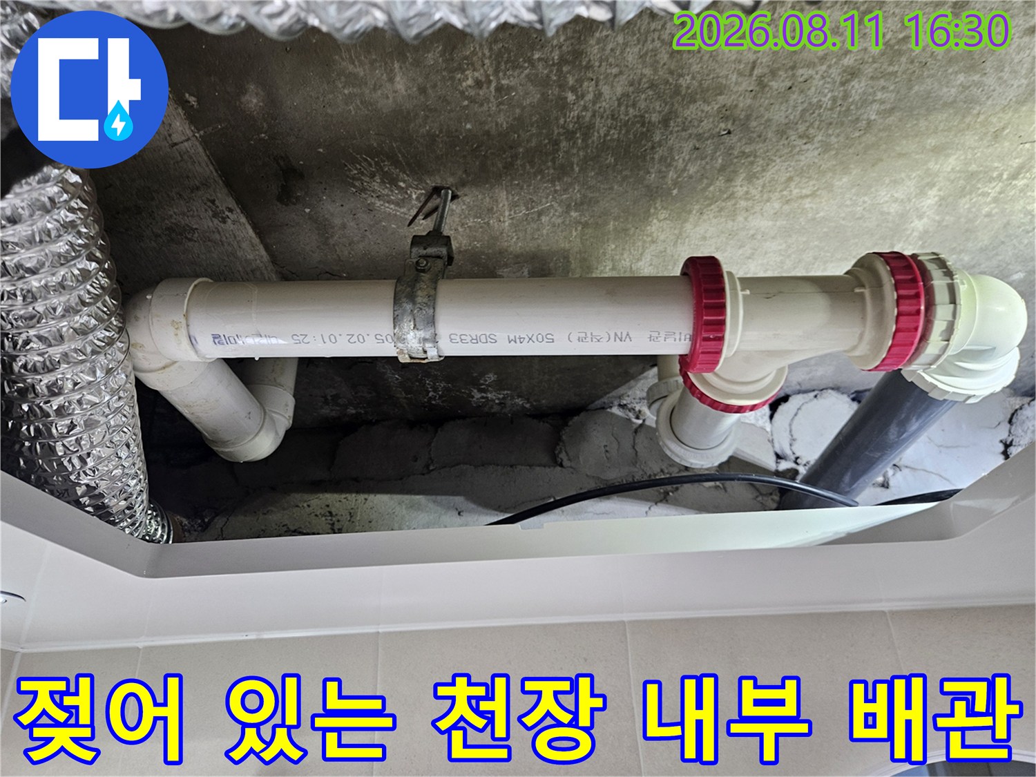 물기가 맺혀 있는 화장 배관 연결부와 콘크리트 구조물