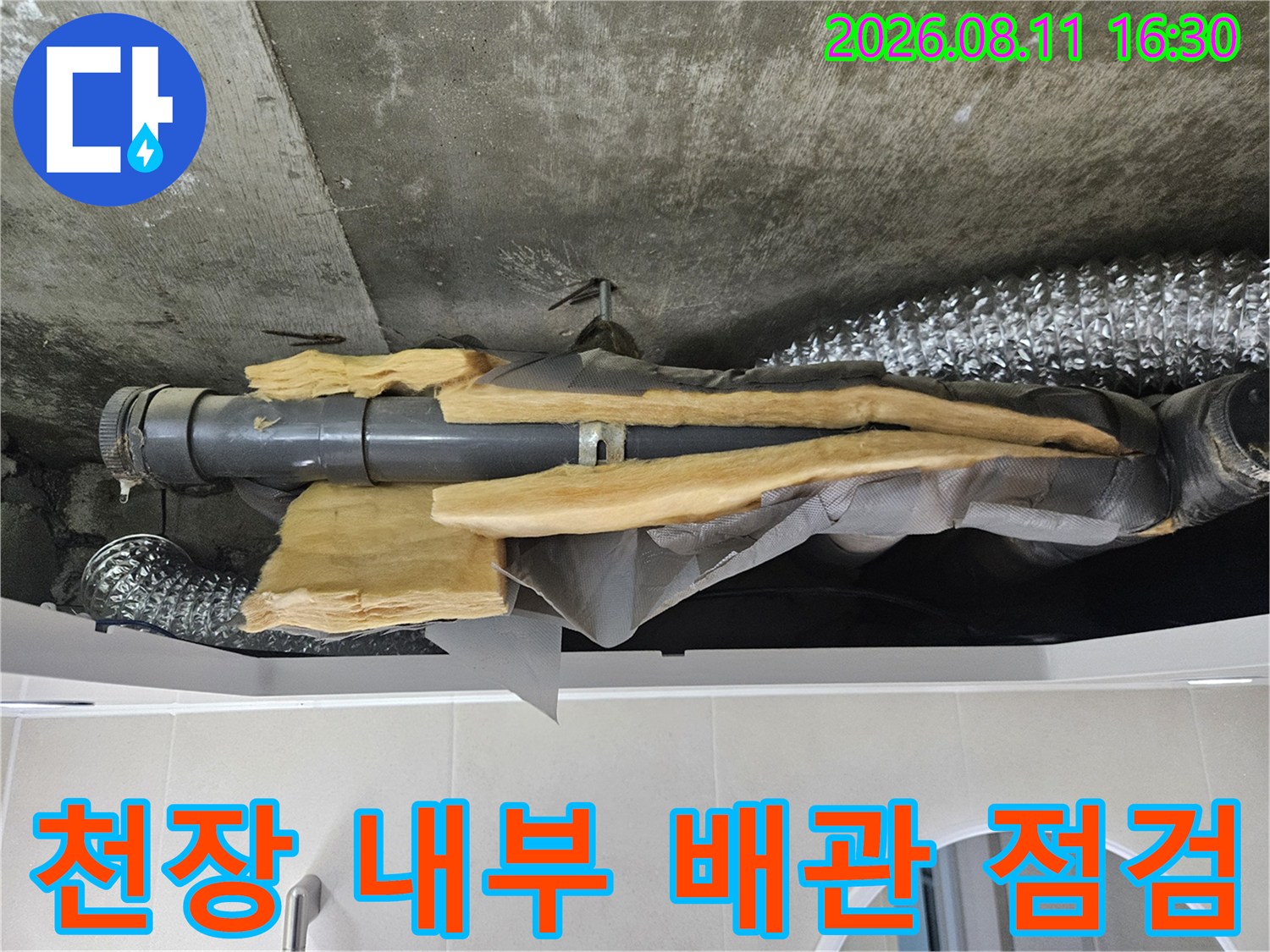 물기가 스며든 보온재와 노후된 배수 배관의 상태를 보여주는 사진입니다.