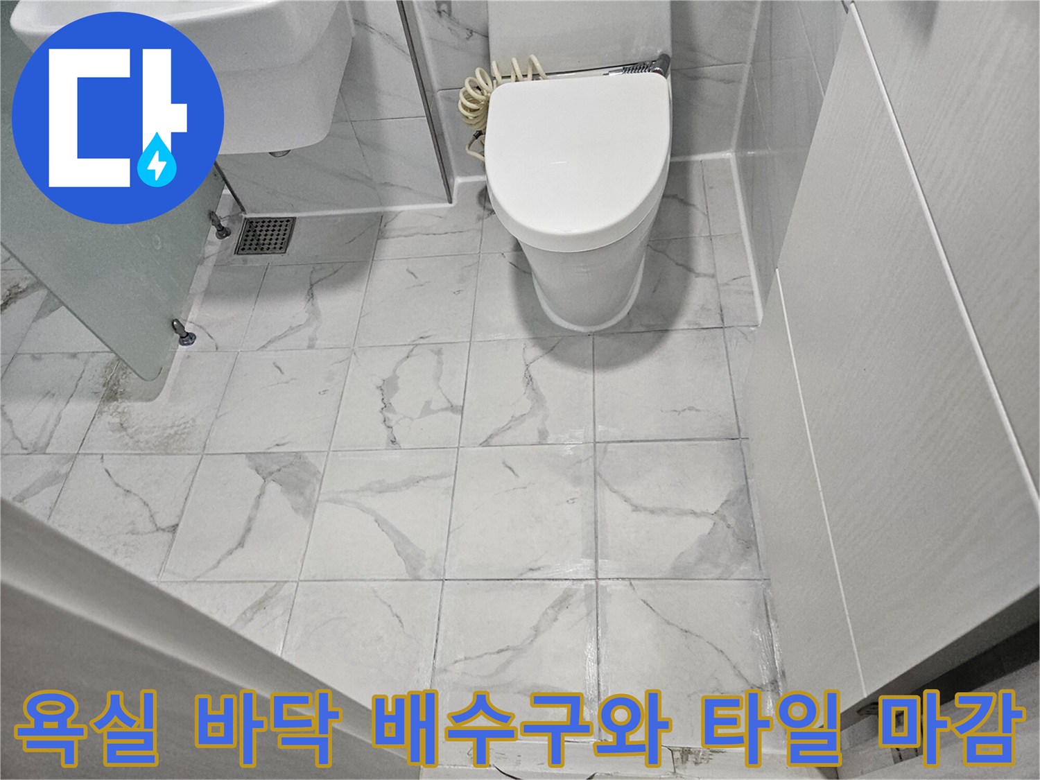 화이트 톤의 대리석 패턴 타일-배수구 유가 주변의 마감 상태 사진