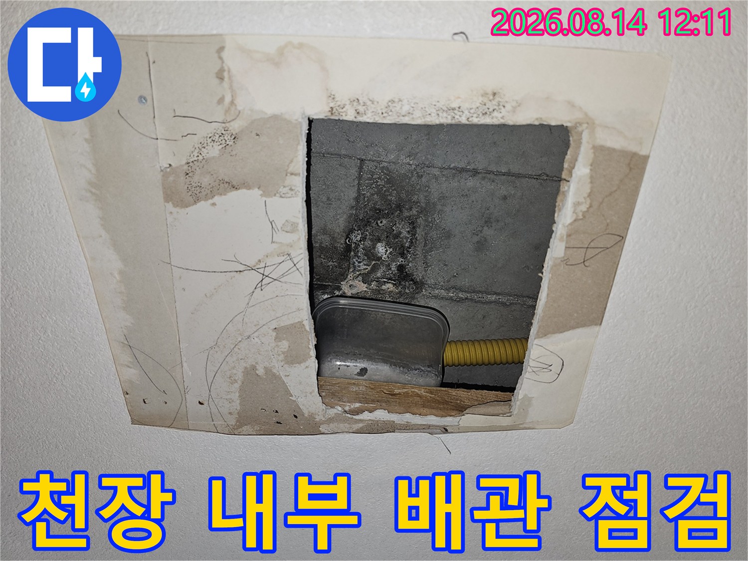 타공된 천장 안쪽의 콘크리트 슬래브와 노란색 주름관 모습입니다.