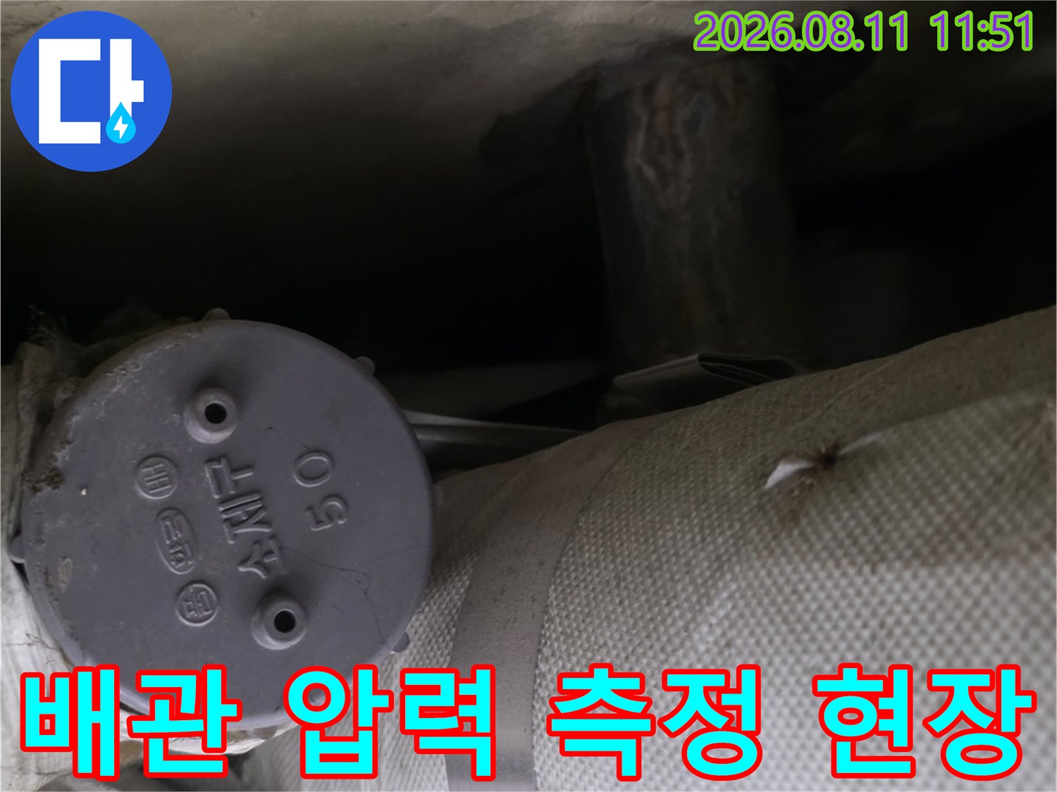 하얀 배관 보온재와 연결된 숫자 표시 압력계의 근접 사진입니다.