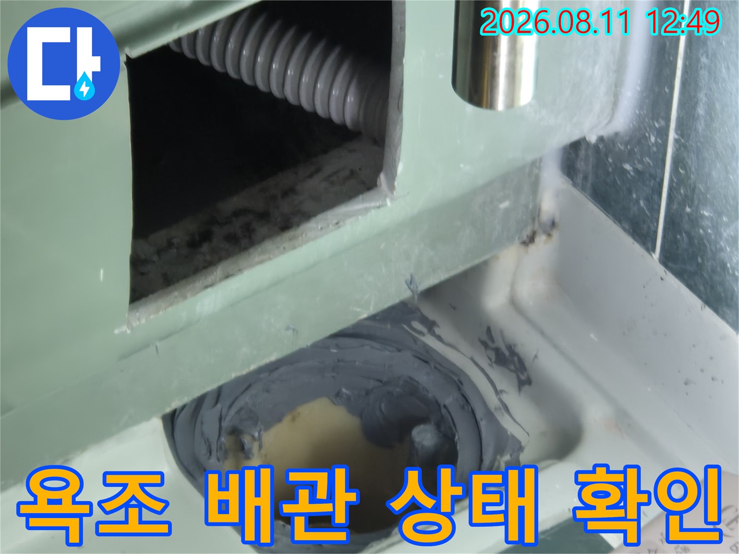 욕조 측면 패널을 절개하여 내부 배수 배관의 연결 부위를 점검하는 모습