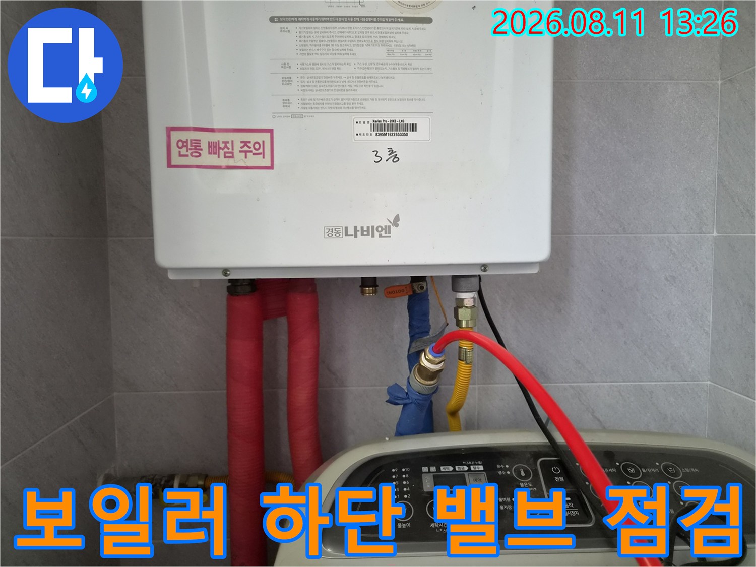 보일러 본체 아래쪽의 밸브와 배관 연결 부위를 근접 촬영했습니다.