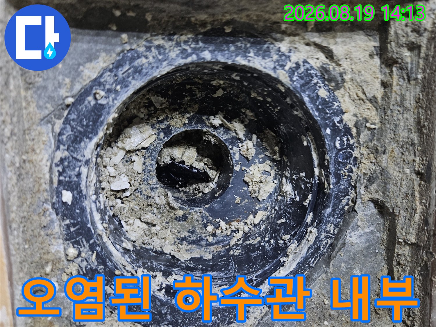 배수구 주변의 오염된 이물질과 훼손된 배관 상태를 나타냅니다.