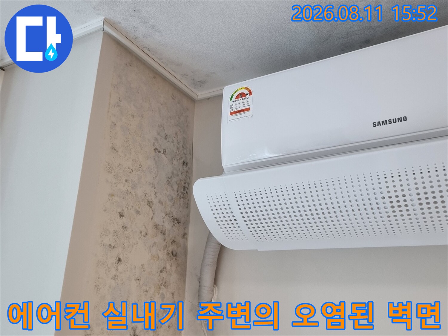 하얀색 에어컨 본체 아래쪽으로 검은 곰팡이가 핀 벽지와 선반-누수 피해 양상