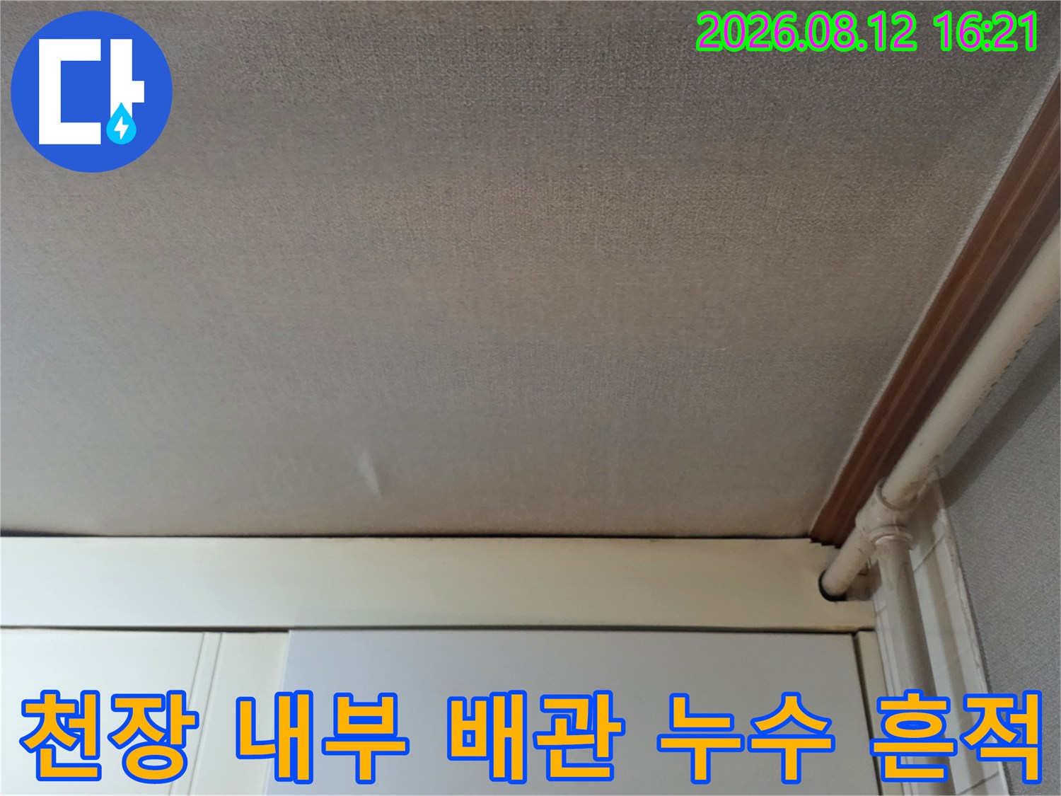 오른쪽 상단에 노출된 흰색 배관-습기로 인해 얼룩진 천장 마감재 상태