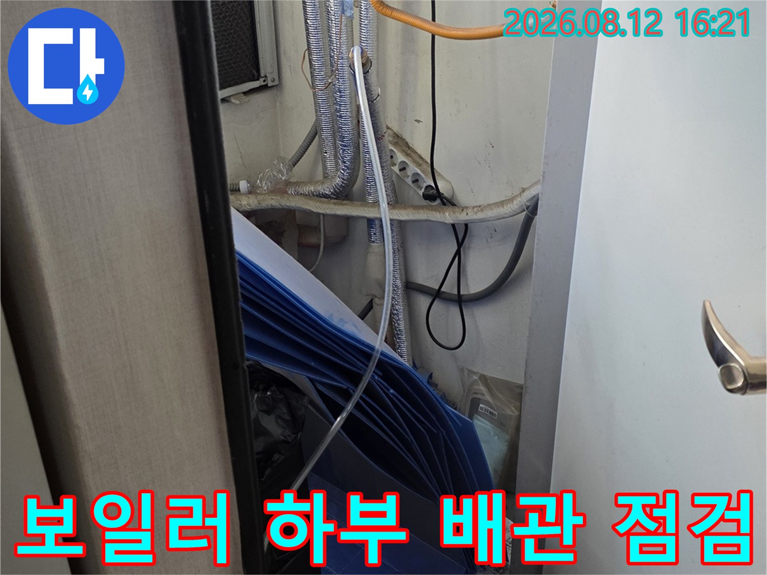은색 단열재가 적용된 여러 가닥의 배관-노란색 전선이 함께 설치된 보일러 하단부