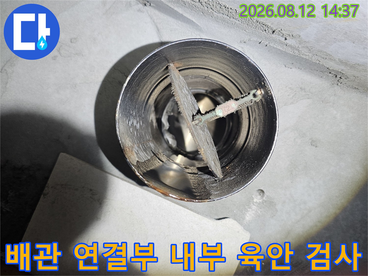 시멘트 마감재 중앙에 위치한 원형 배관과 내부에 설치된 금속 부품-상태