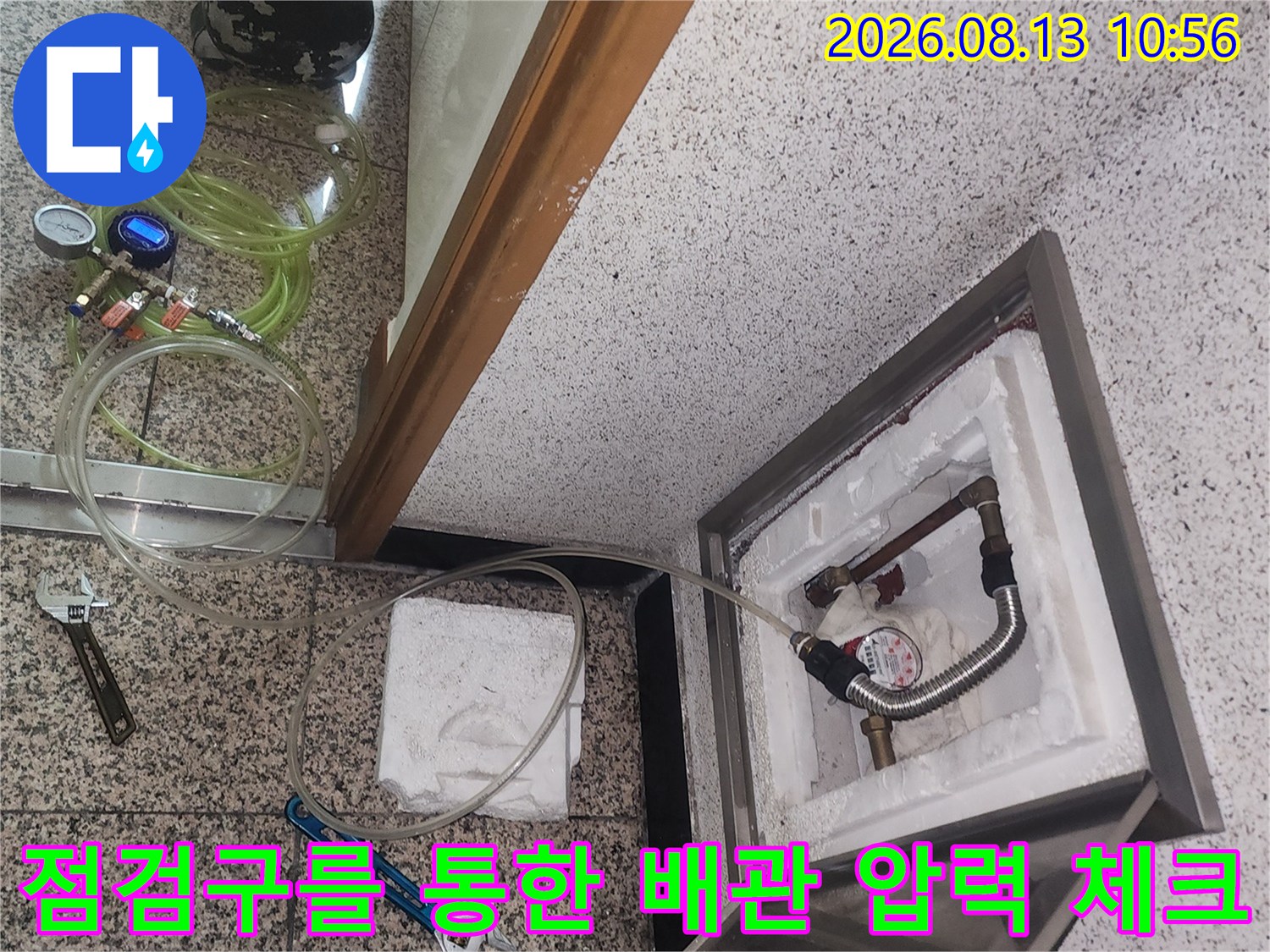 금속 점검구 내부의 단열재와 배관에 설치된 공압 측정 장비를 촬영한 사진