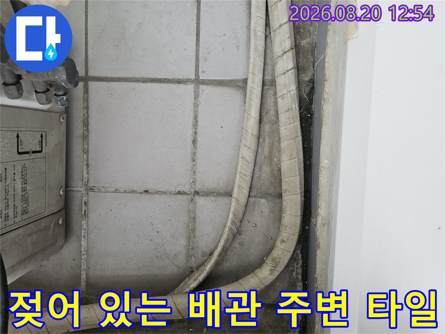 물기가 스며든 베란다 타일과 우수관 배관 모습