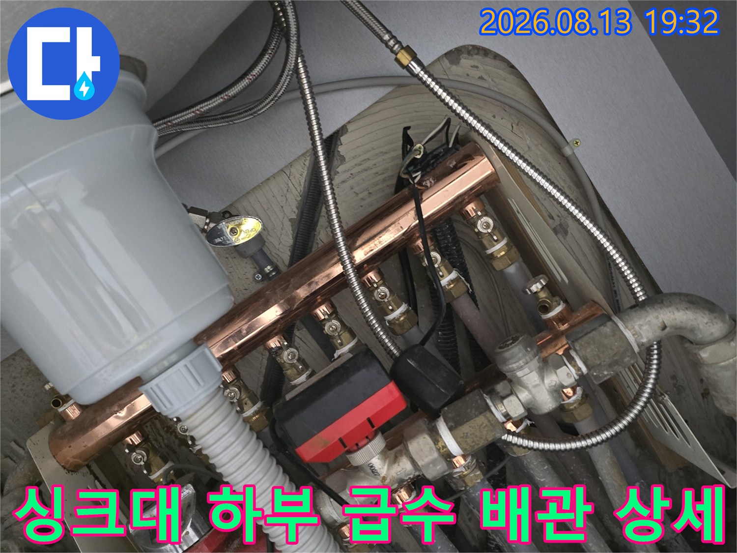 싱크대 내부의 구리 분기 관과 연결된 각종 밸브와 호스 모습