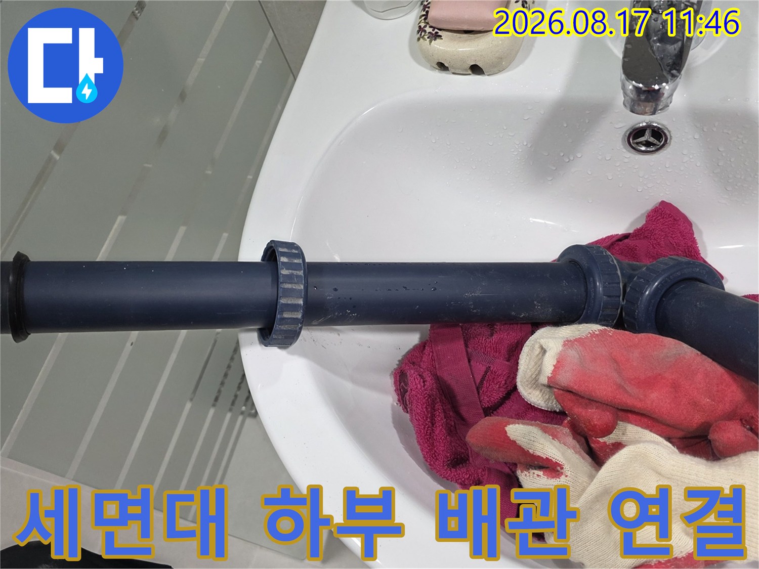 세면대 아래 검은색 배관과 연결 소켓 부위를 근접 촬영하였습니다.