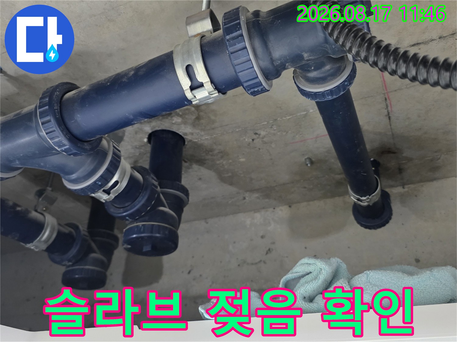 파란색 배관 주변으로 습기가 찬 천장 슬라브를 근접 촬영한 사진입니다.