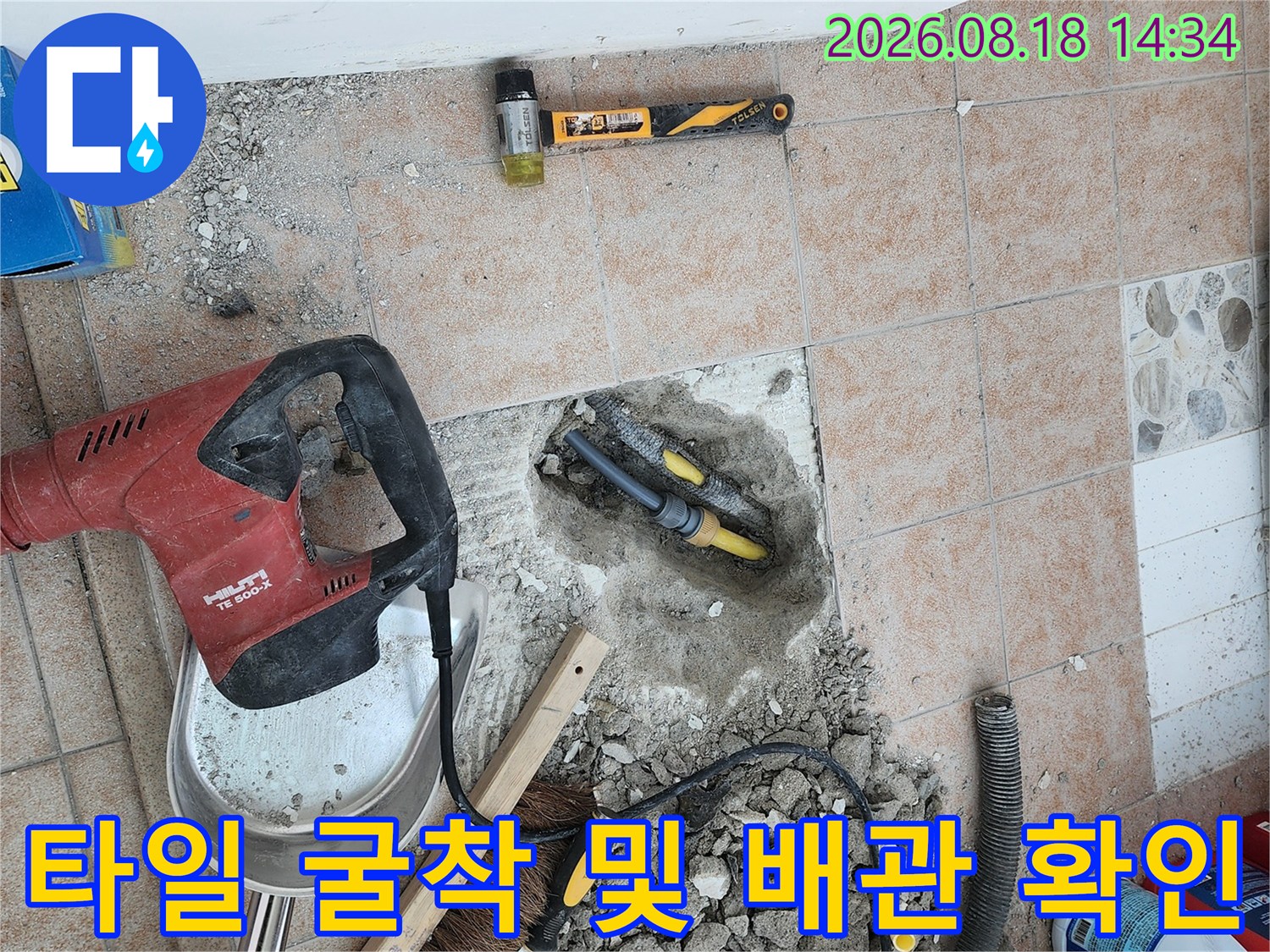 바닥 타일을 제거하고 드러난 손상된 배상 배관과 공구들