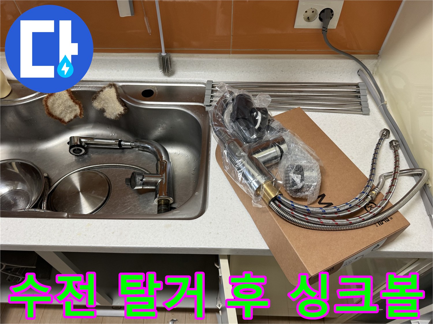 수전이 제거된 빈 싱크볼과 옆에 놓인 새 수전 상자입니다.