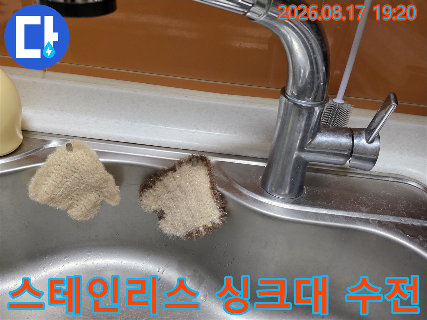 스테인리스 싱크대 볼에 설치된 반짝이는 크롬 수전 모습