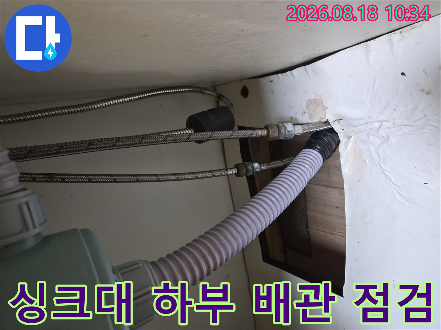 기흥구 공세동 싱크대 하부의 온수 고압 호스 및 배수관 연결 상태를 보여줍니다.