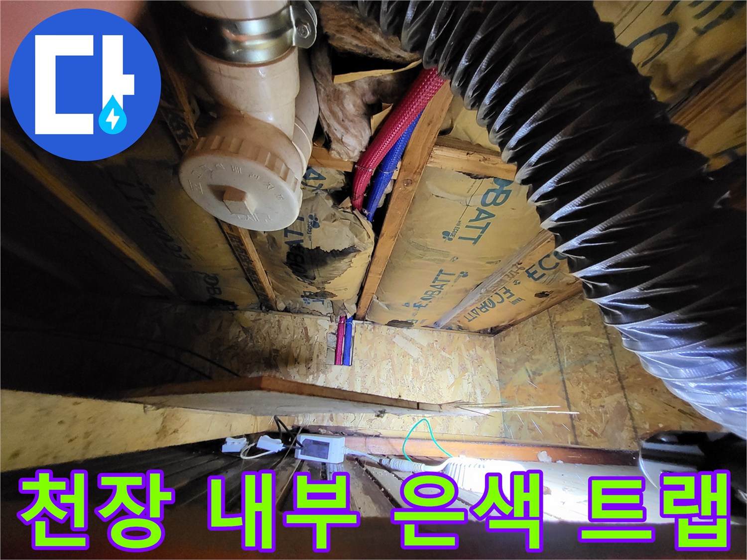 목조 구조물 사이에 설치된 은색 배수 트랩과 호스들