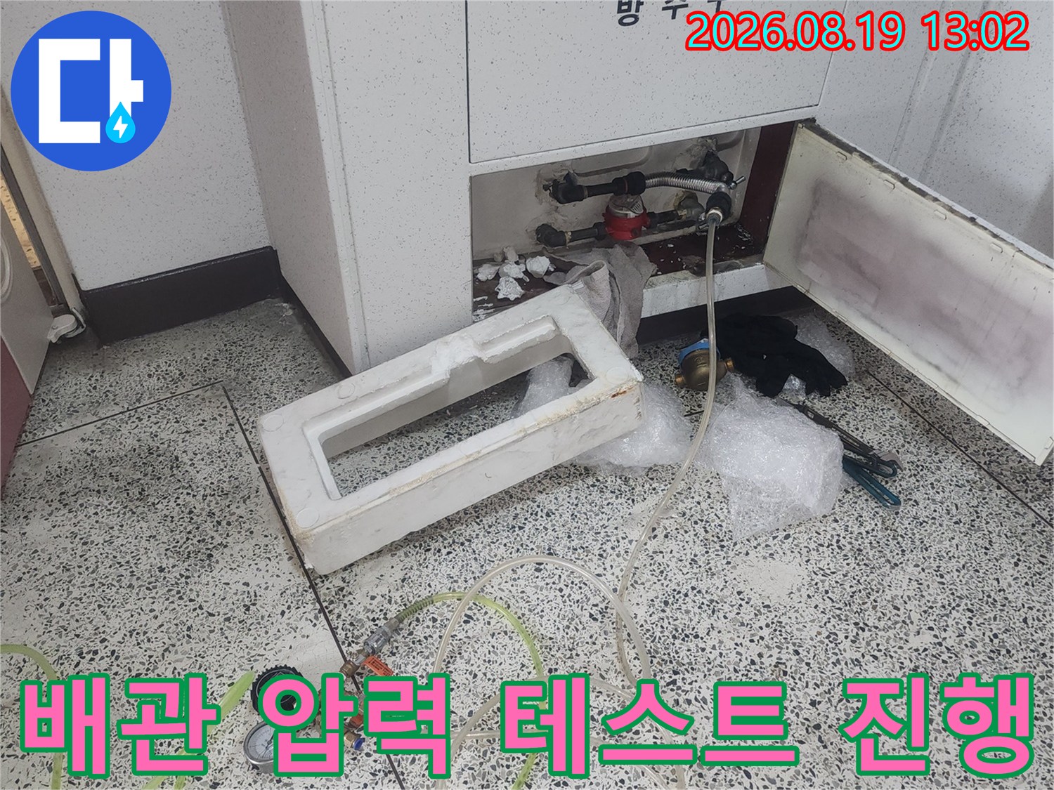 싱크대 하단 배관에 연결된 공압 측정기와 압력 게이지의 상세 모습