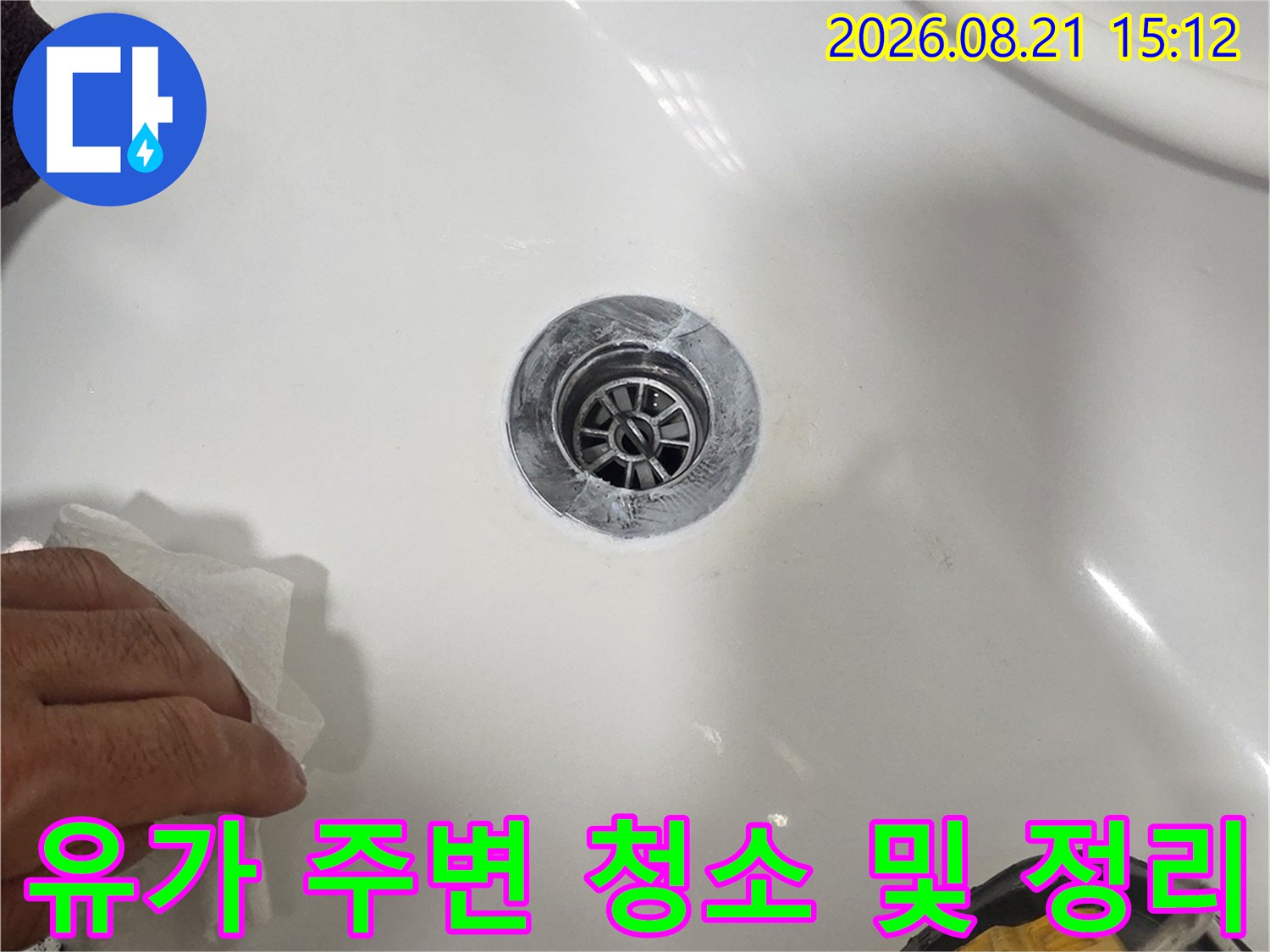 전동 드릴과 세척 도구를 사용하여 배수구 부속 주변을 정비하는 장면입니다.
