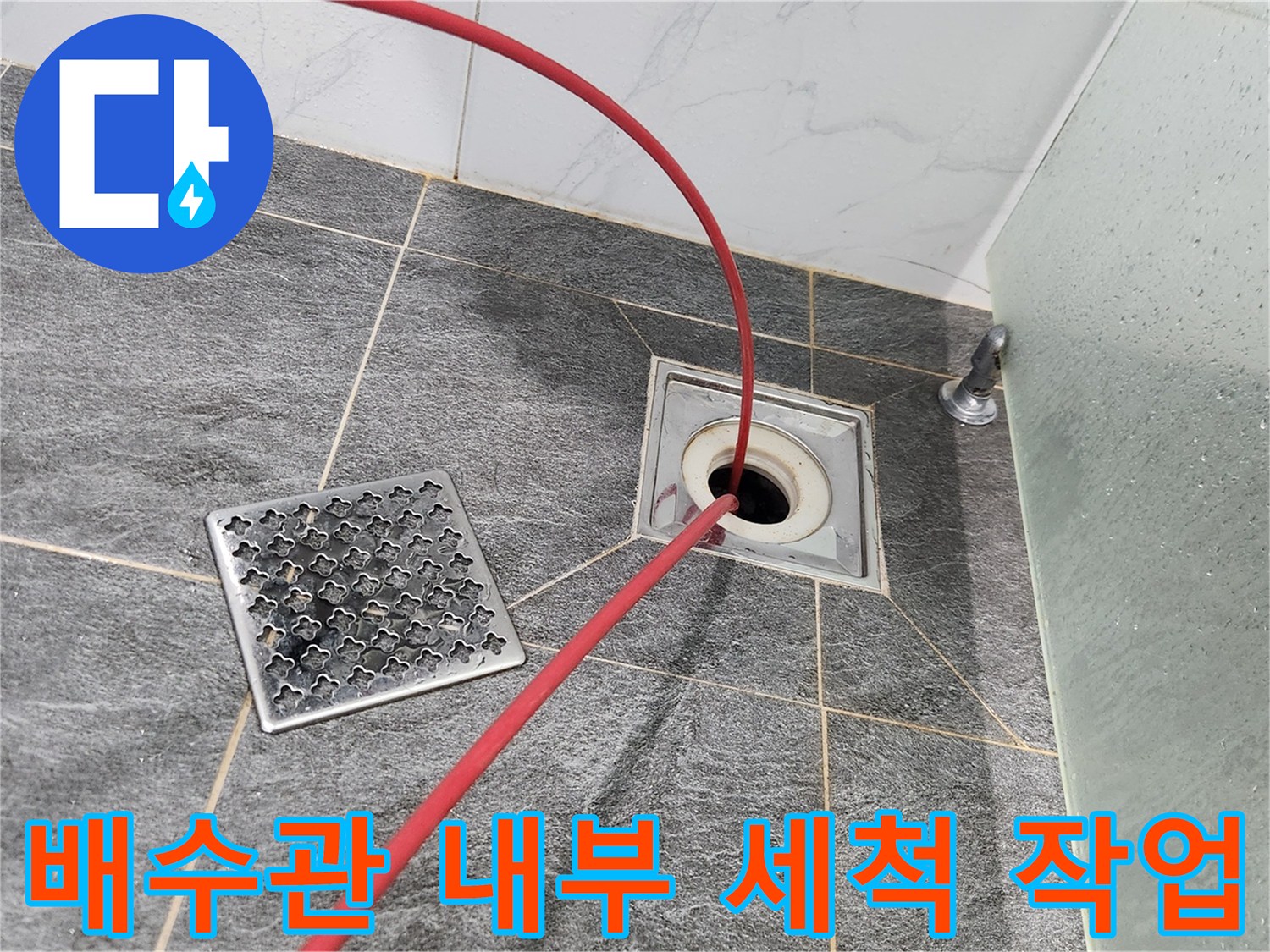 화장실 배수구 입구에 삽입되어 작동 중인 붉은색 샤프트 선