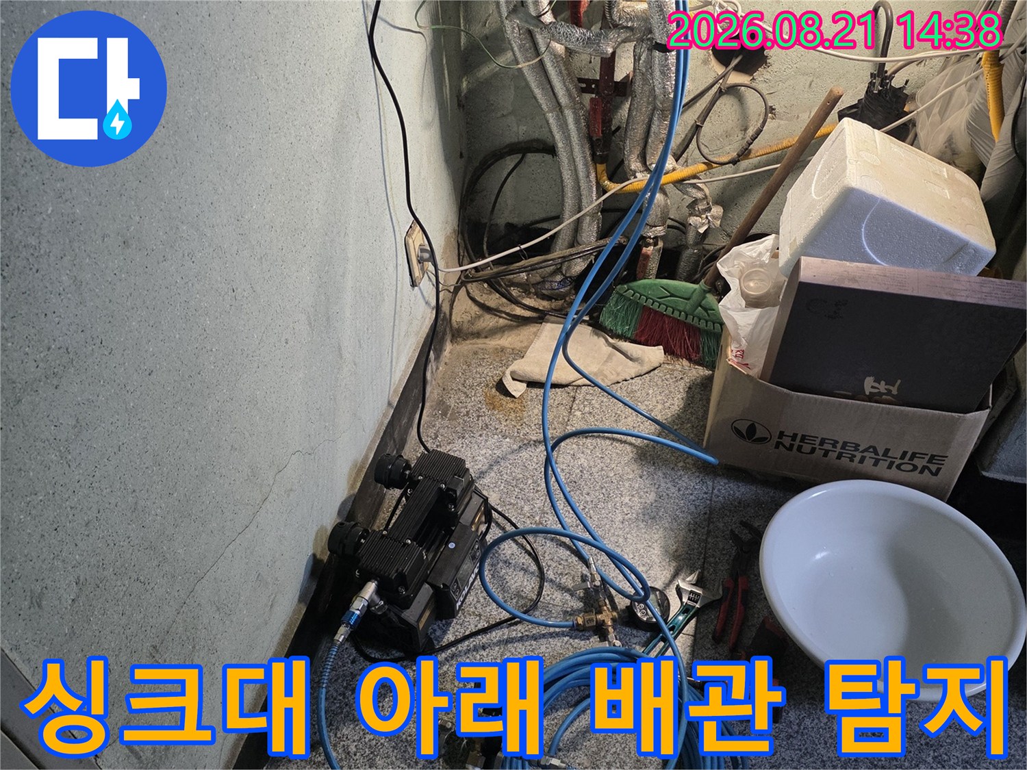 싱크대 밑 배관 구역에 배치된 누수 탐지 장비의 모습입니다.