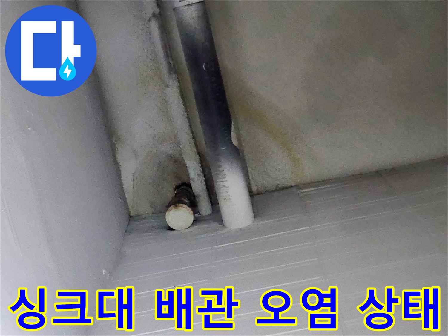 싱크대 하부장 배관 주변의 누수 흔적과 오염된 벽면 모습