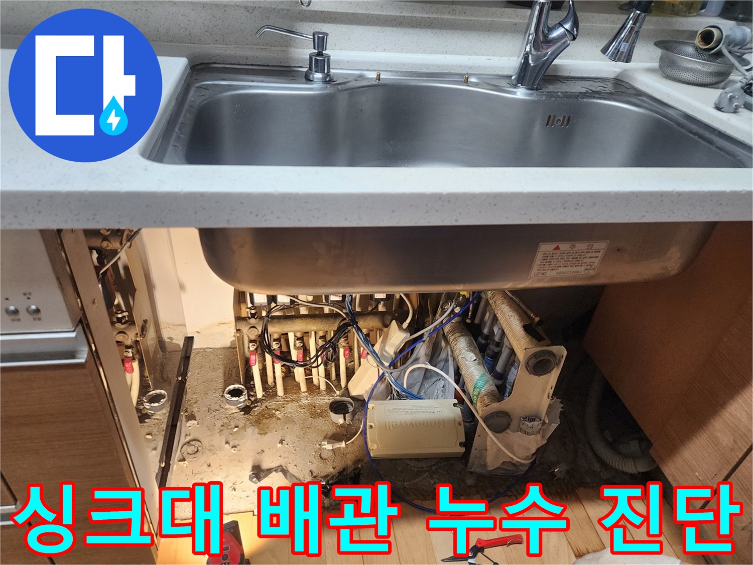 싱크대 밑 배관 연결 부위와 젖어 있는 하부장 바닥 상태