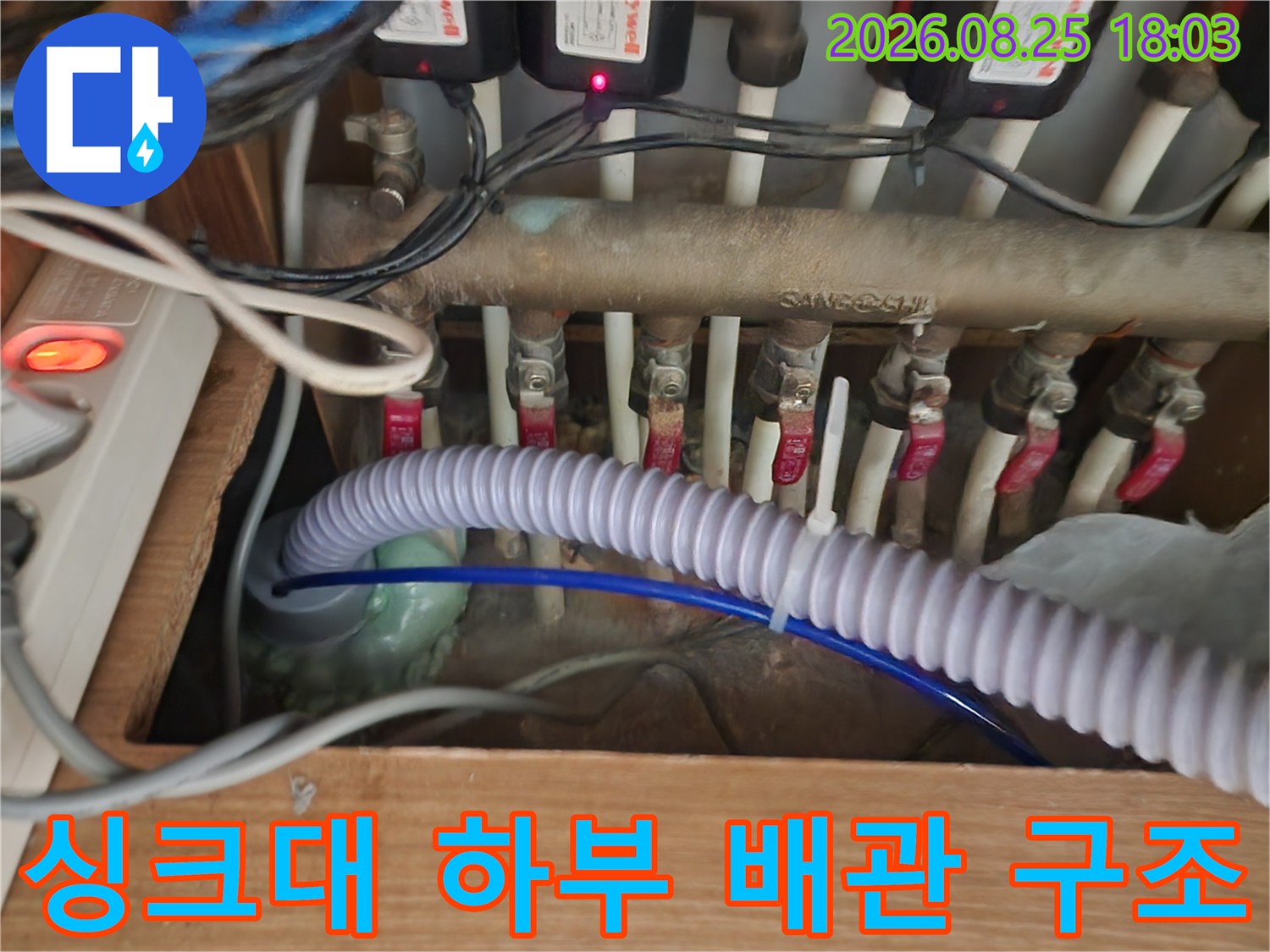싱크대 아래쪽 수도 분기 밸브와 연결된 다양한 급수 배관의 모습
