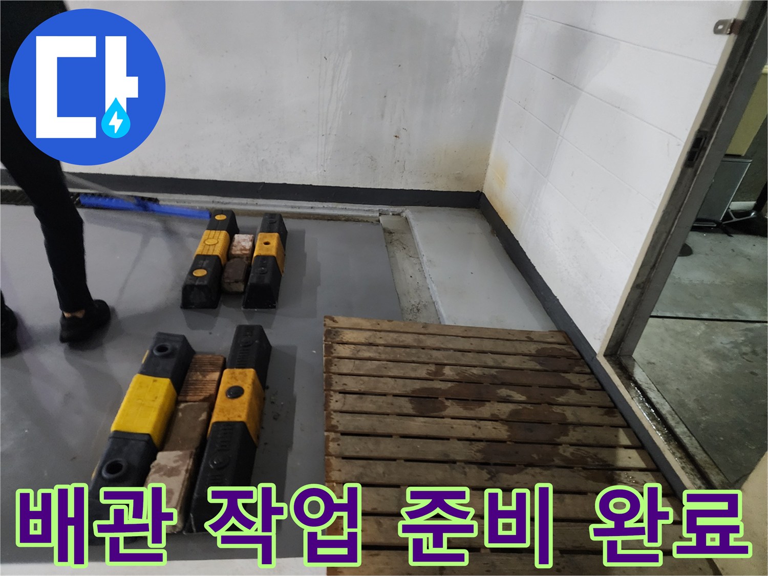현장 바닥에 배치된 노란색 보양재와 배관 청소용 장비입니다.