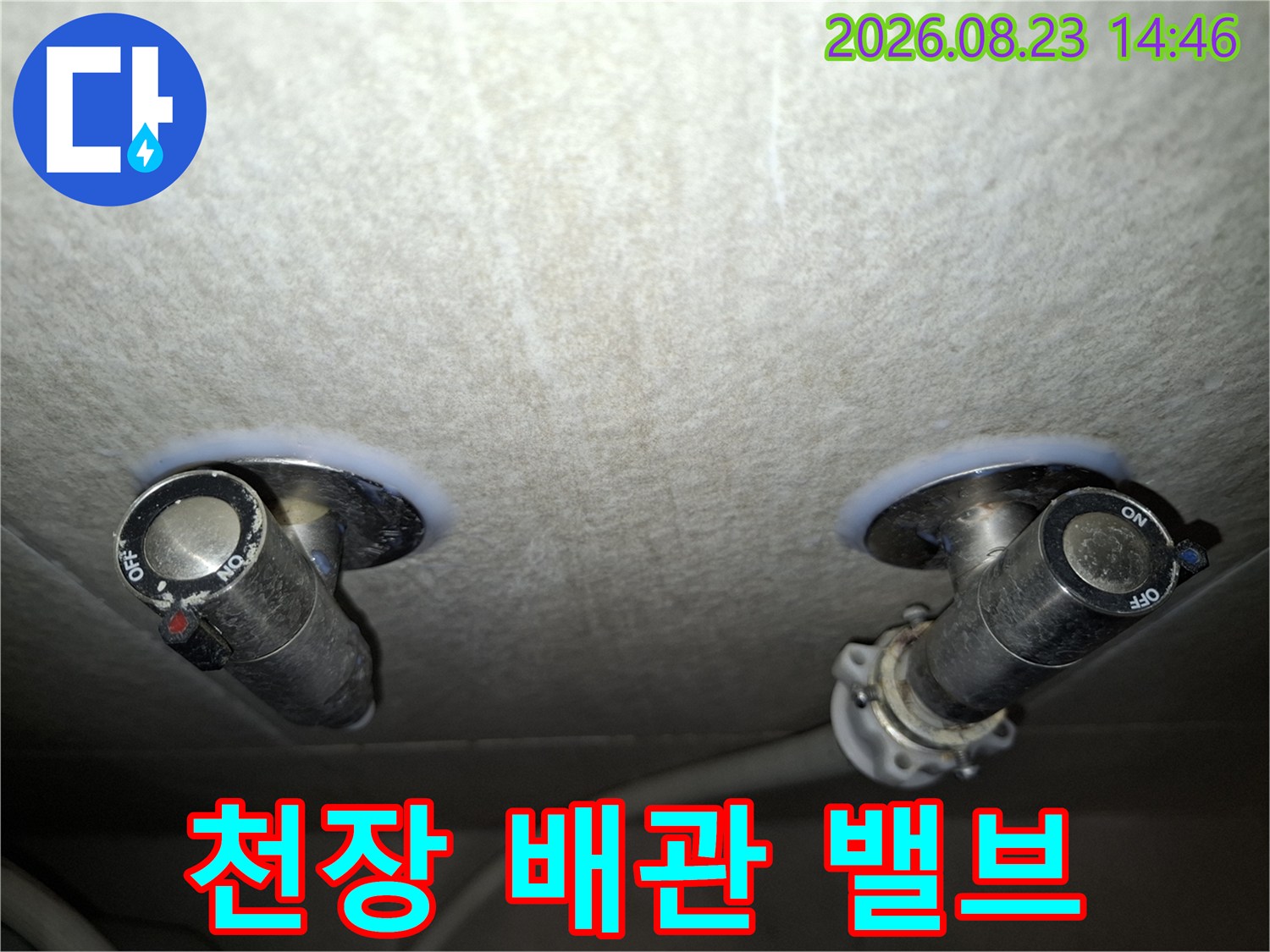 천장 내부로 노출된 검은색 배관 밸브와 주변 연결 부위의 상태를 보여줍니다.