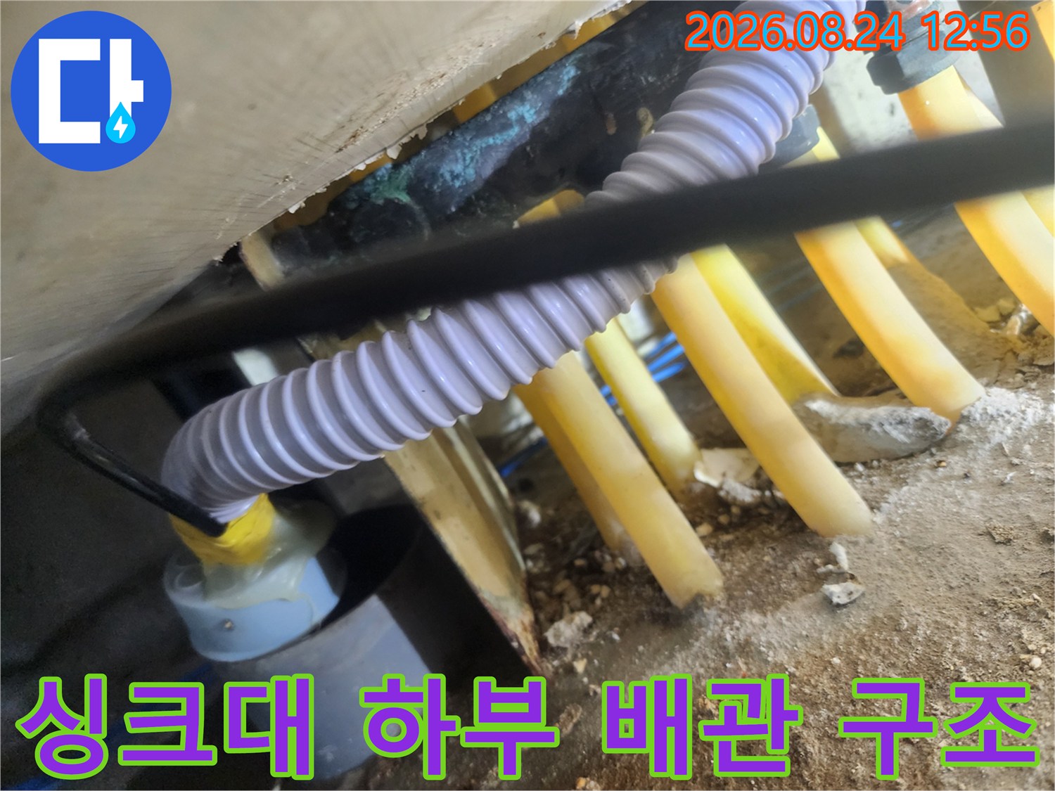 싱크대 밑 노란색 배관과 흰색 주름 호스의 연결 상태