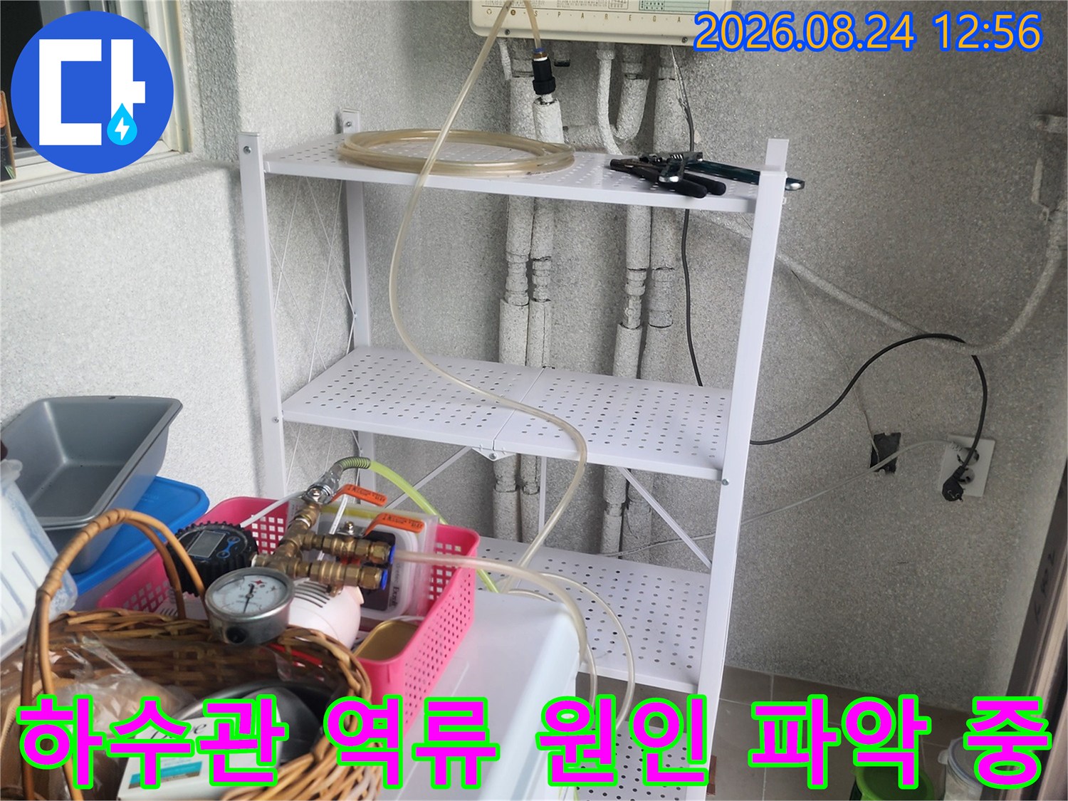 싱크대 하부 배관과 연결된 점검용 호스 및 장비들
