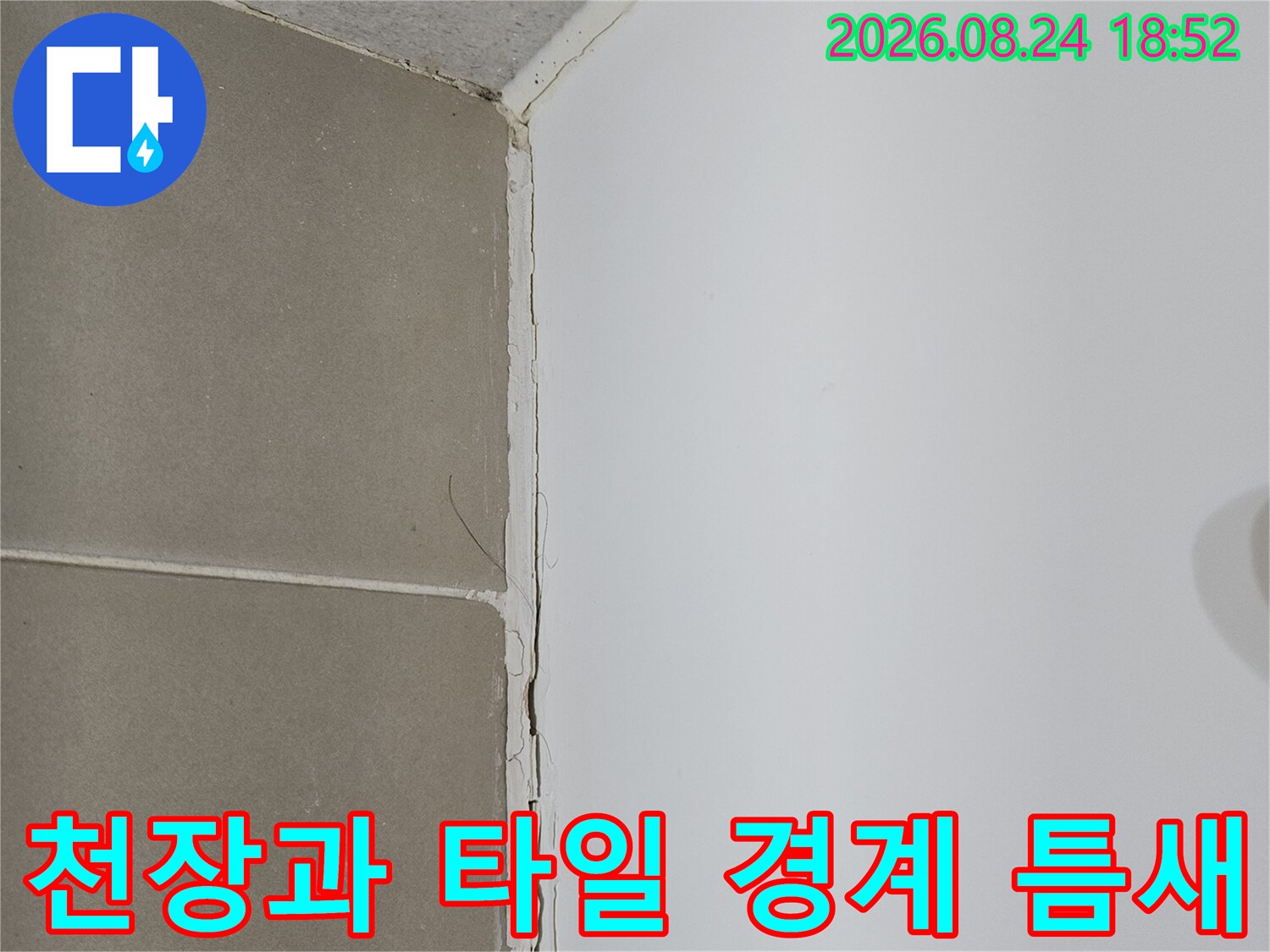 천장 마감재와 욕실 벽면 타일 사이의 벌어진 공간을 촬영한 사진입니다.