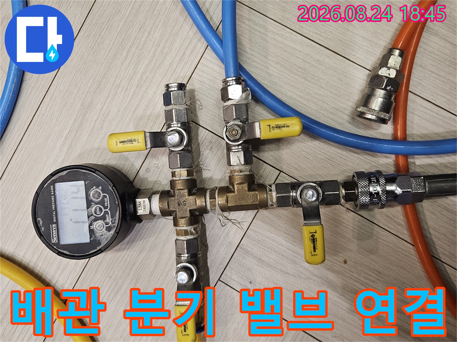 다양한 호스가 연결된 배관 분기 밸브와 압력 측정 장치 모습입니다.