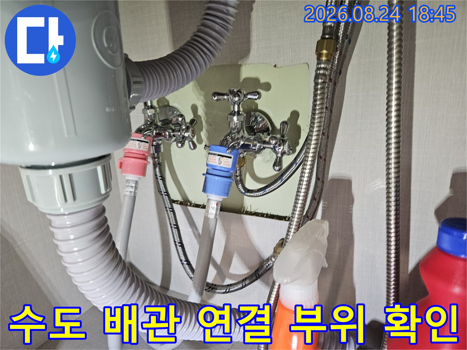 세탁실 벽면에 설치된 수도꼭지와 호스 연결 상태를 나타내는 사진입니다.