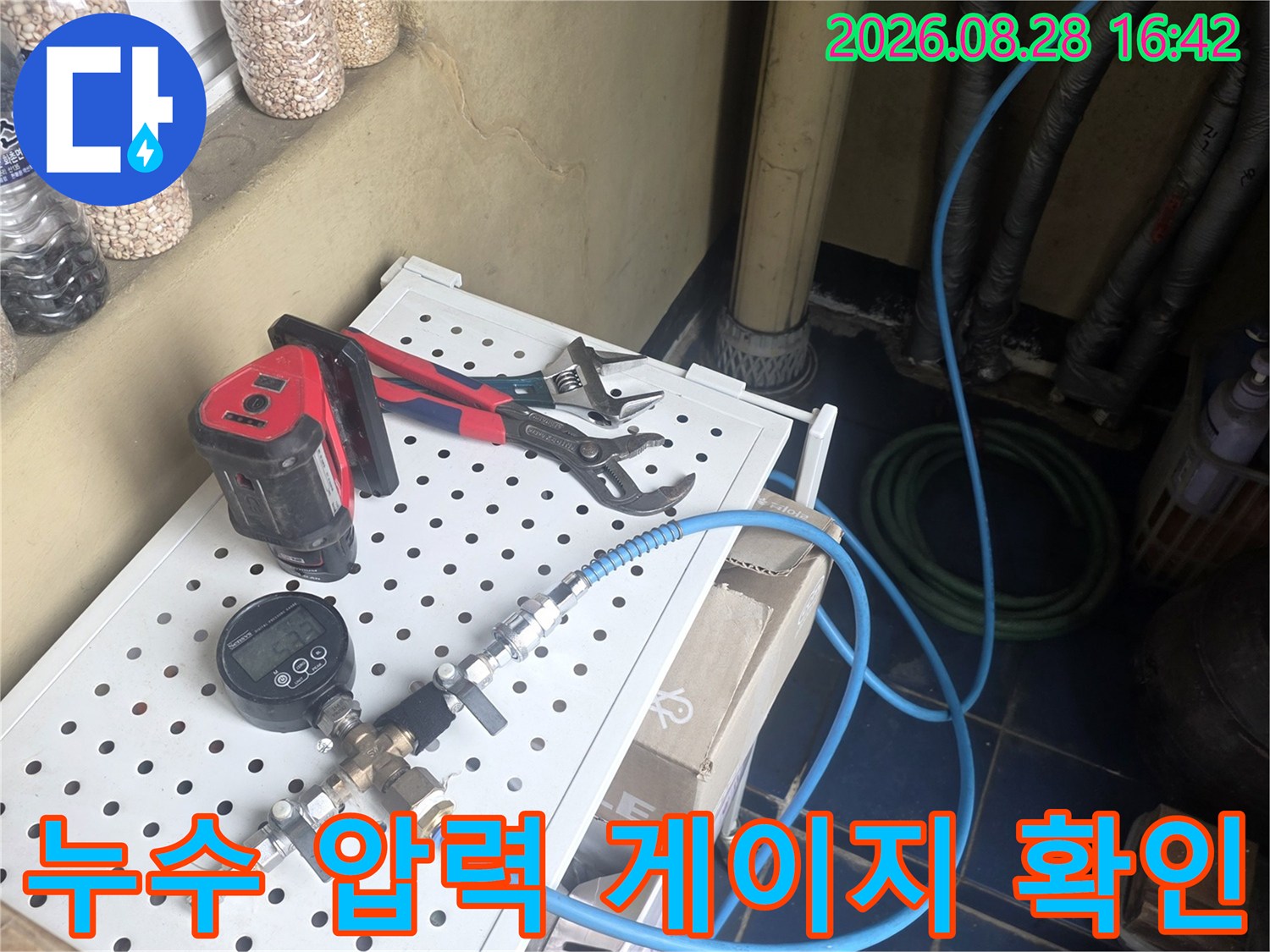 수도 배관의 누수 여부를 측정하기 위한 압력 게이지와 호스 연결