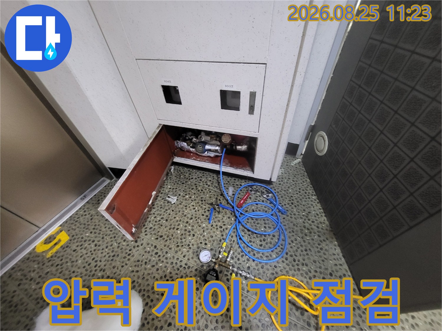 계량기함에 연결된 압력 측정 장비와 호스 모습입니다.