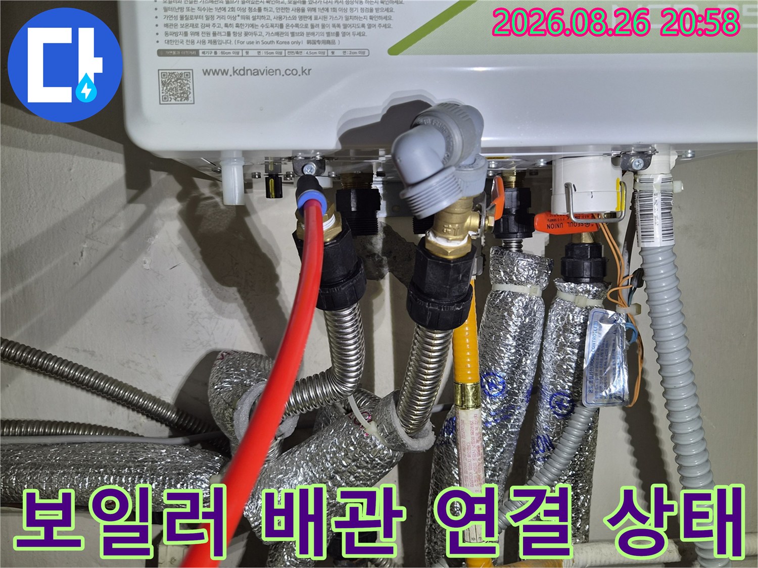 보일러 하단에 연결된 다양한 배관과 보온재 마감 상태를 보여주는 사진입니다.