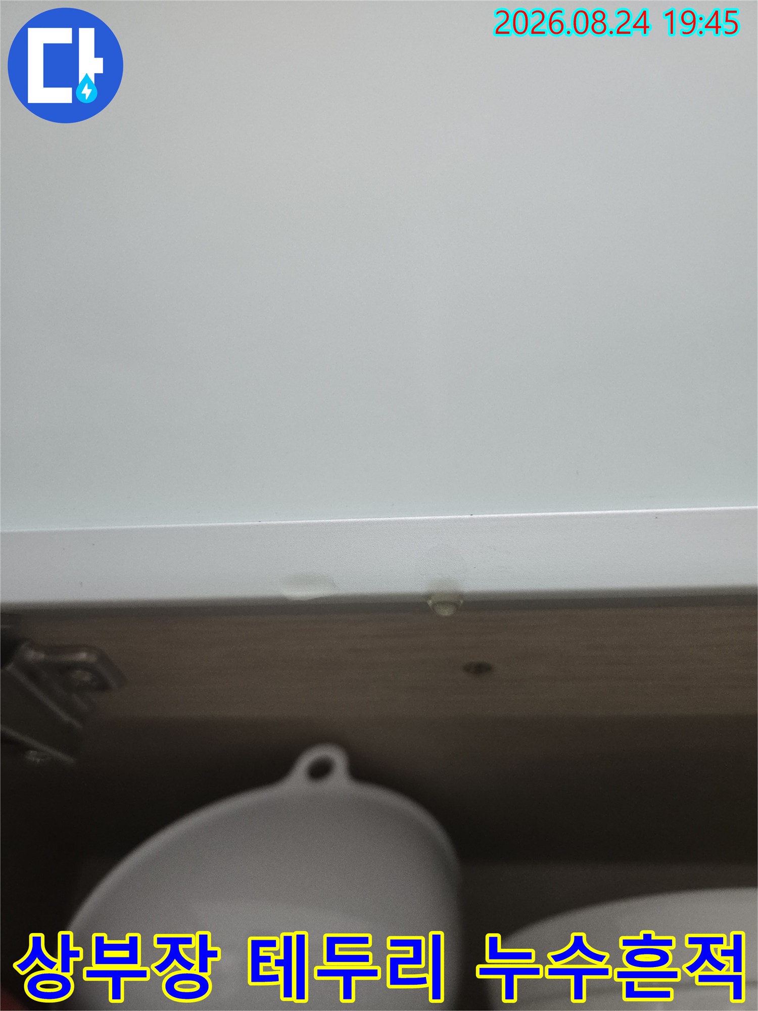 상부장 하단 마감재에 보이는 작은 물자국과 습기 부위
