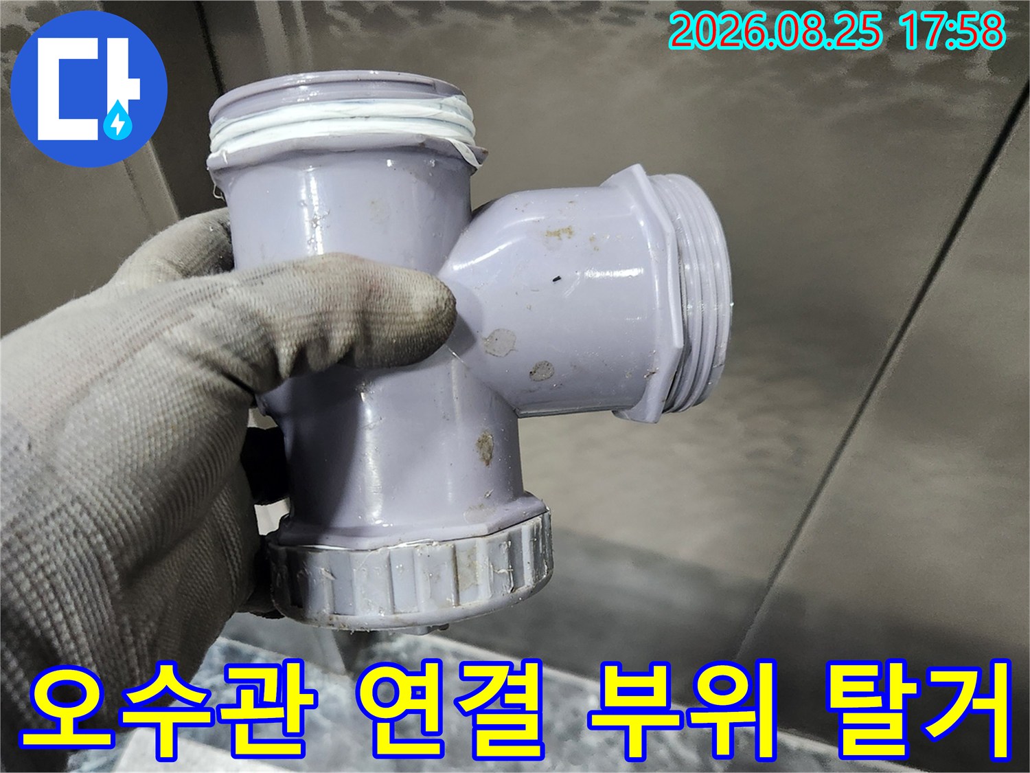 누수가 발생한-오수관 부속을-엔지니어가 손으로 잡고 있는 사진