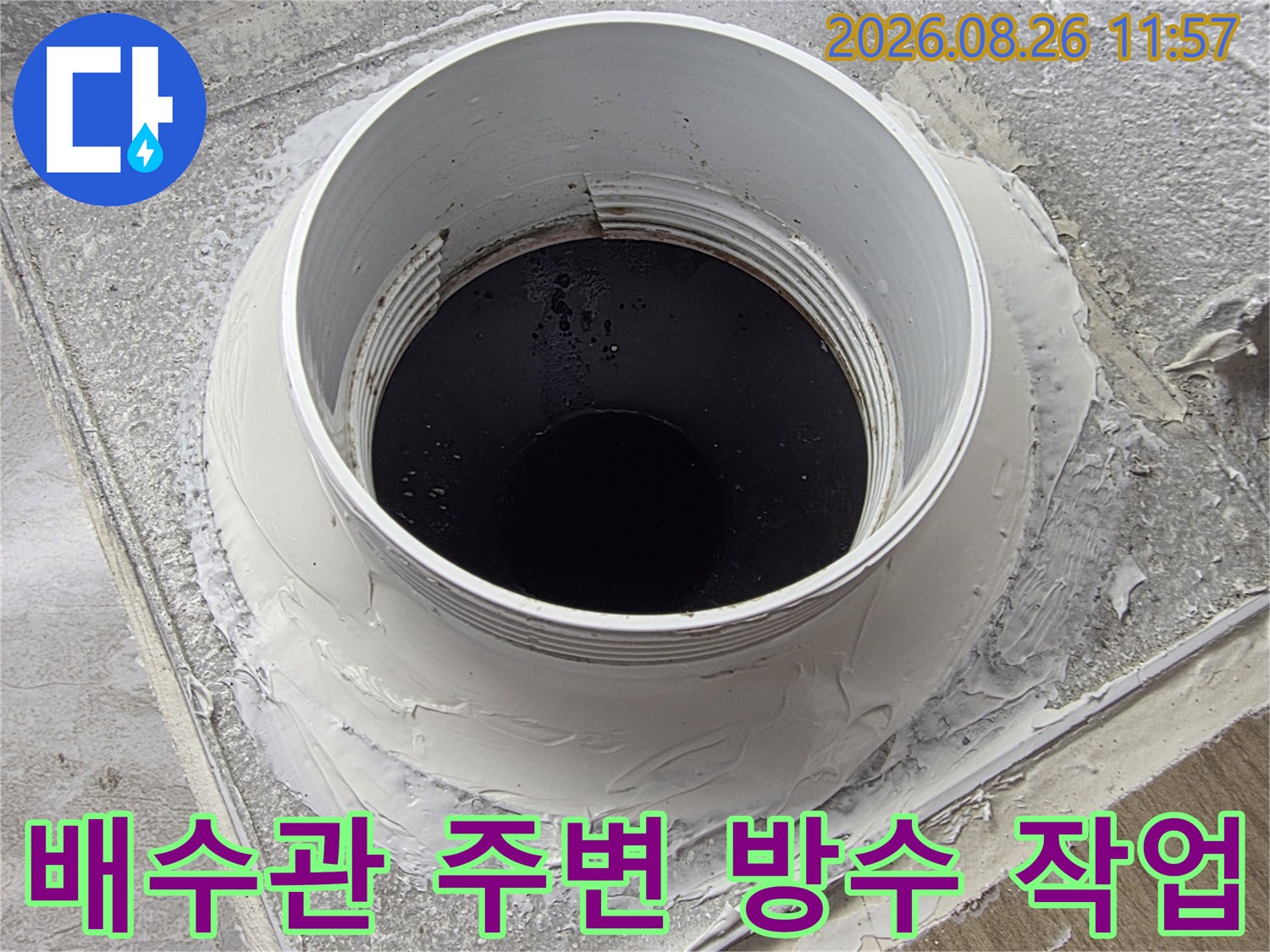 하얀색 배수관 겉면에 방수재를 도포하여 누수를 차단하는 모습입니다.