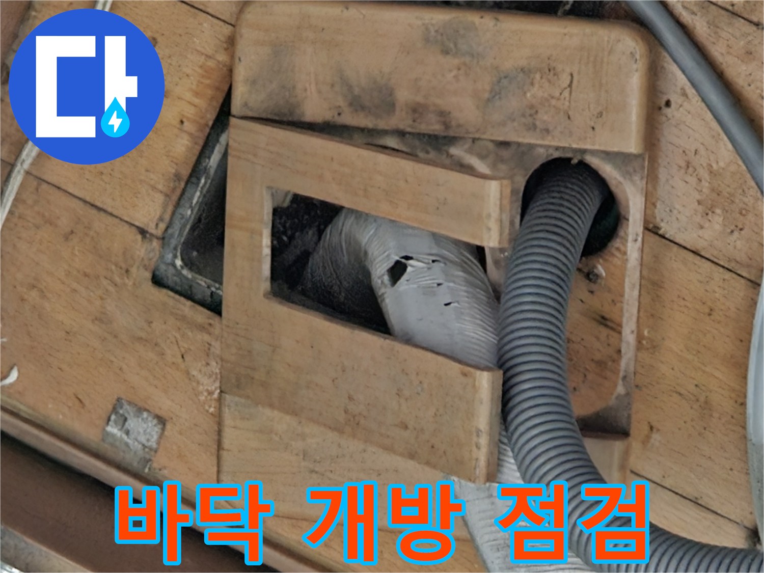 나무 지지대 사이로 보이는 배관 연결 구간