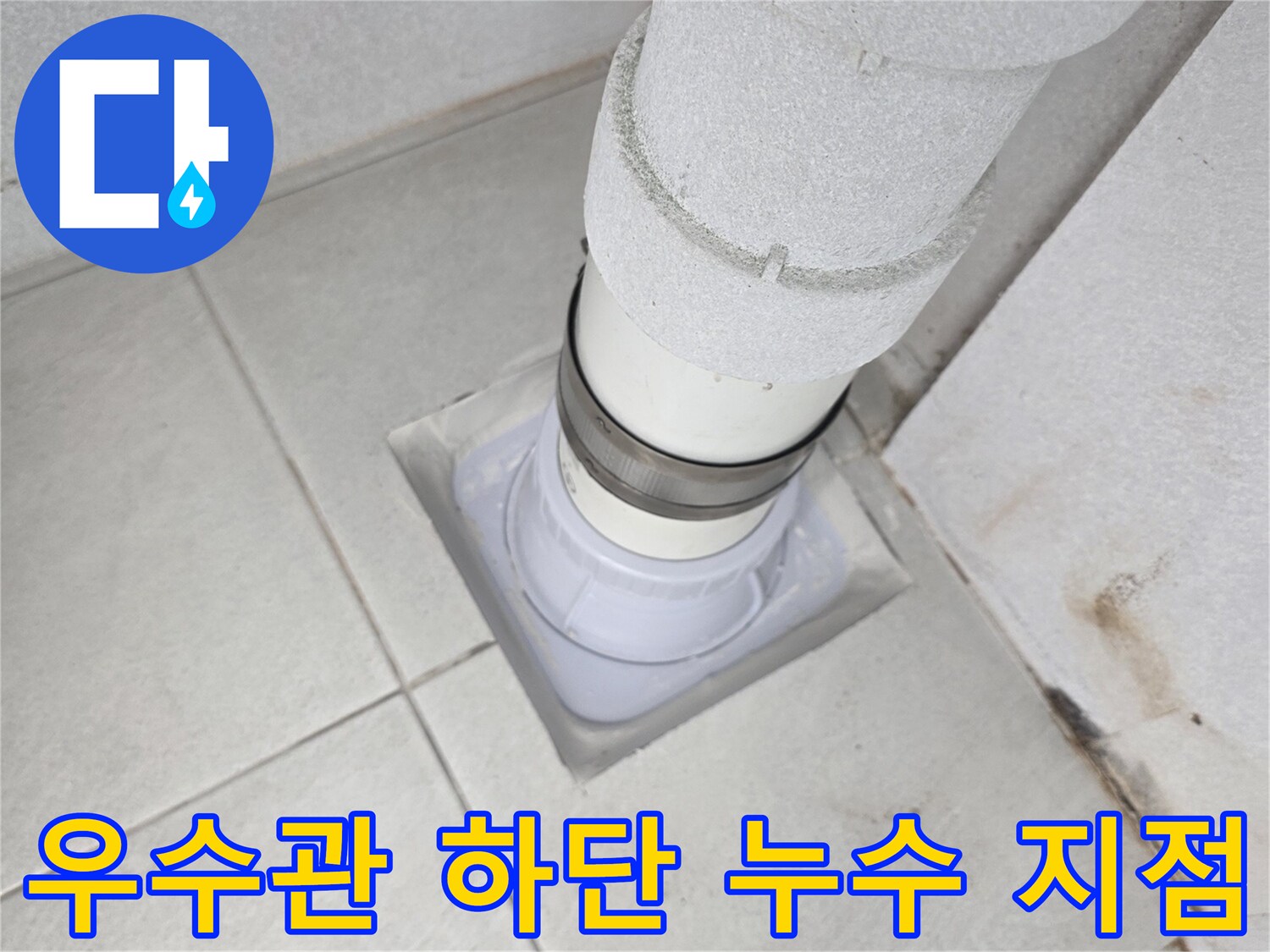 배관 연결 부위 - 물에 젖어 변색된 타일과 우수관 소켓